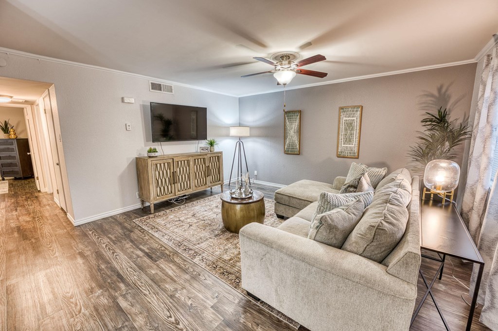 a living room with a couch and a ceiling fan at Juniper Springs Apartments, Austin, TX